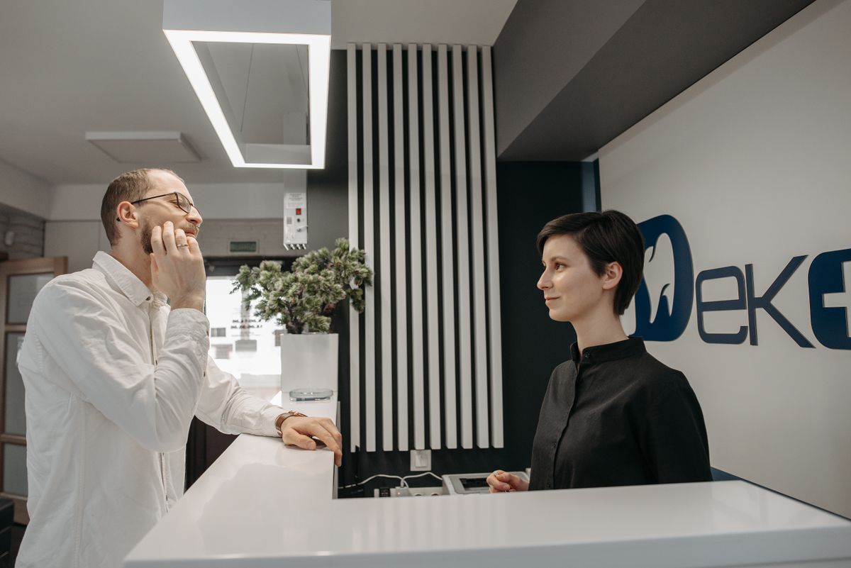 A patient being welcomed at the front desk of Dental Spot