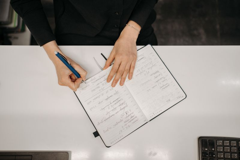 a desk being tidied at the end of the day with a notebook closed