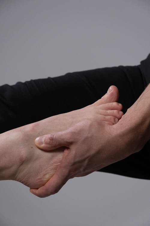 Free Person Holding a Foot Stock Photo