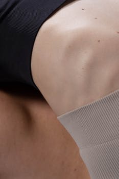 Detailed close-up of a woman's knee wearing sportswear, highlighting flexibility and athleticism.