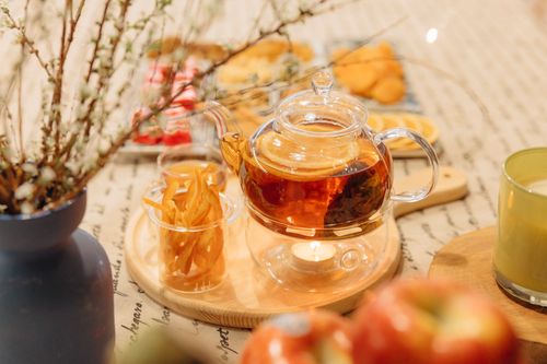 Free A cozy scene with a glass teapot, orange slice, and wooden tray, perfect for a relaxing tea moment. Stock Photo