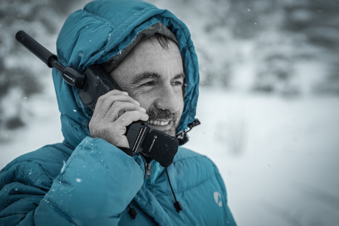 Free Man in Blue Hoodie Jacket Holding Black Radio Receiver during Snowy Day Time Stock Photo