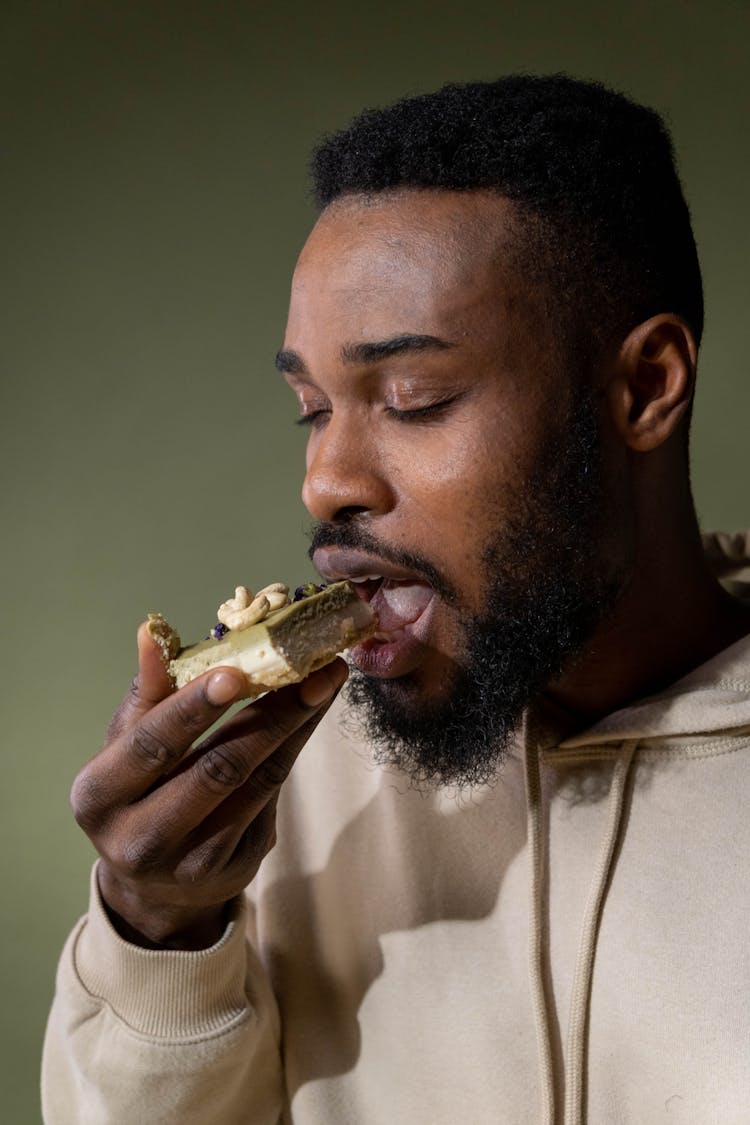 A Man Eating A Layered Cake