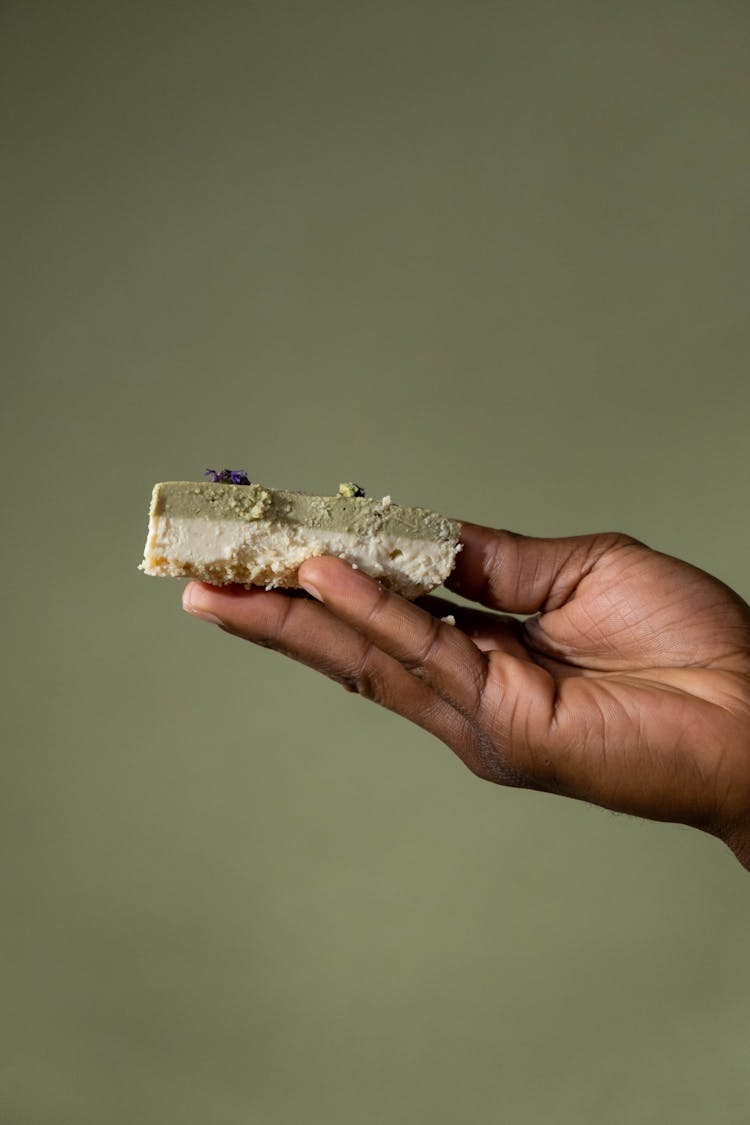 A Person Holding A Piece Of A Layered Cake