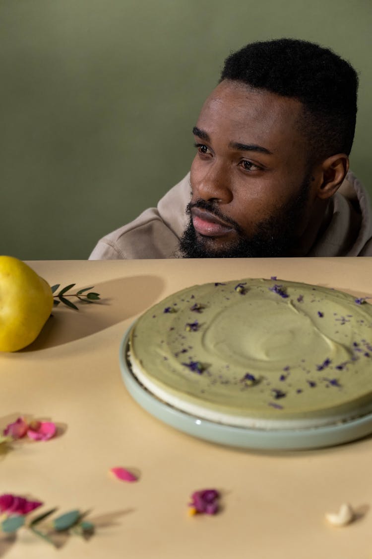 A Man And A Layered Cake On The Table