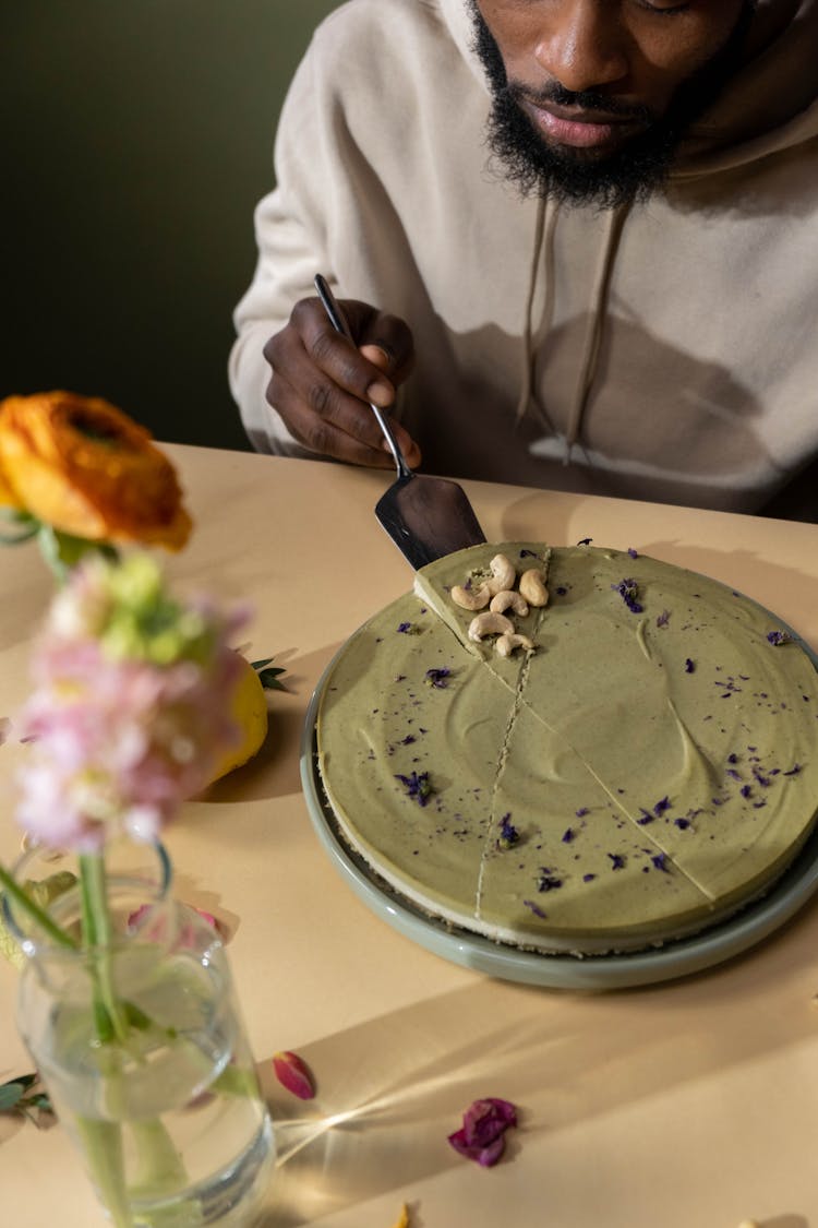 A Person Taking A Piece Of Layered Cake