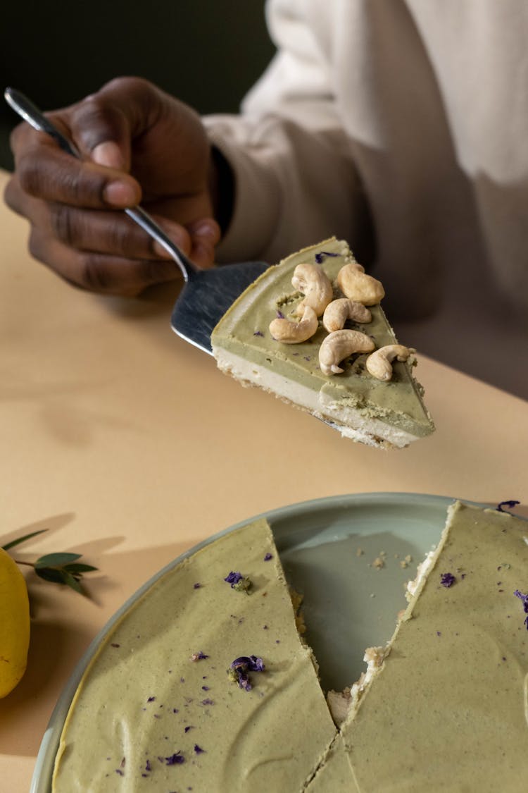 A Person Taking A Piece Of Layered Cake