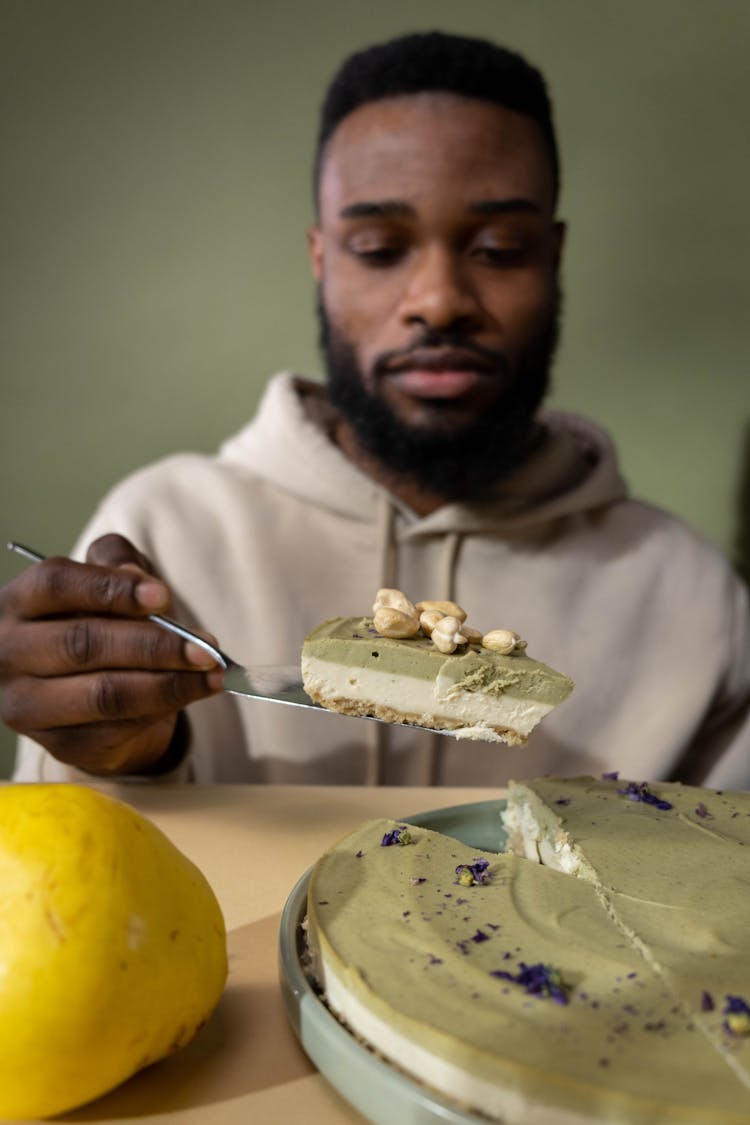 A Person Taking A Piece Of Layered Cake