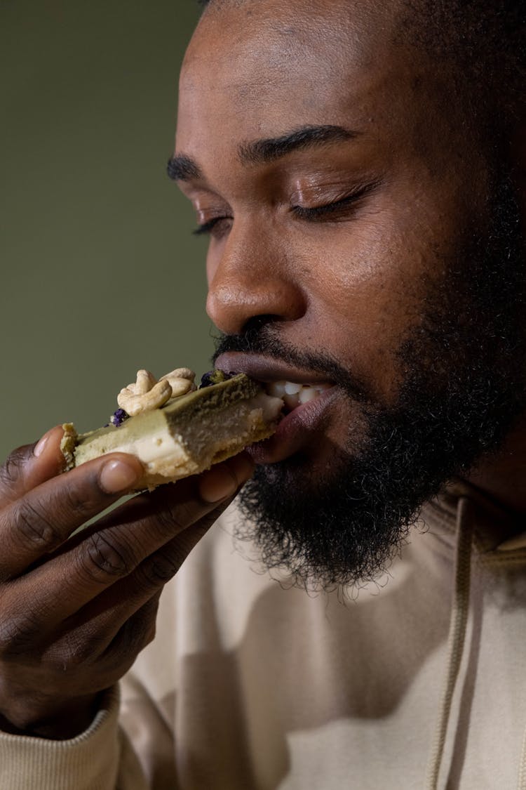 A Man Eating A Layered Cake