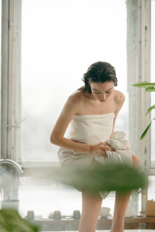 A Woman Sitting Beside the Glass Window