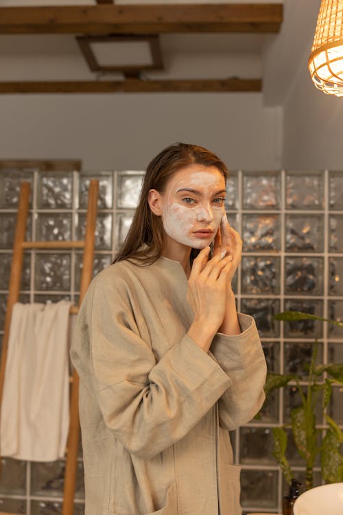Woman Applying Skin Care on Her Face