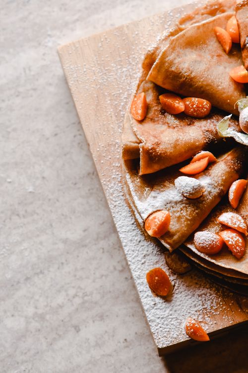 Free Mouthwatering homemade pancakes garnished with cape gooseberries and dusted with powdered sugar. Stock Photo