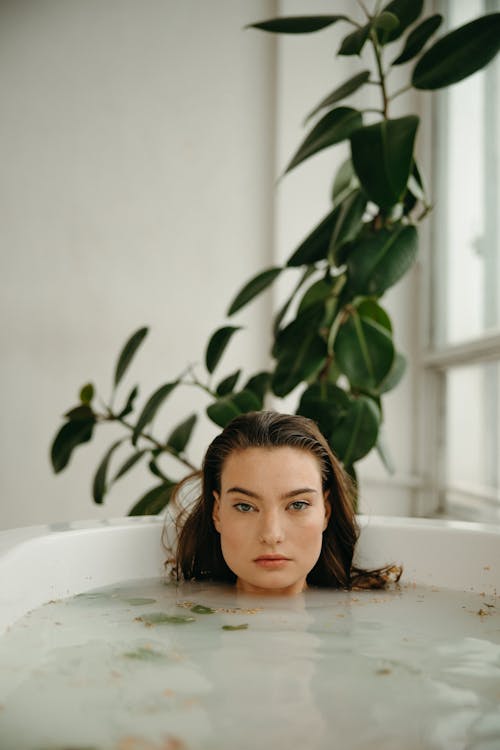 Woman taking bath, man sitting on side of bathtub, looking down at woman -  Stock Photo - Masterfile - Premium Royalty-Free, Code: 695-03381854