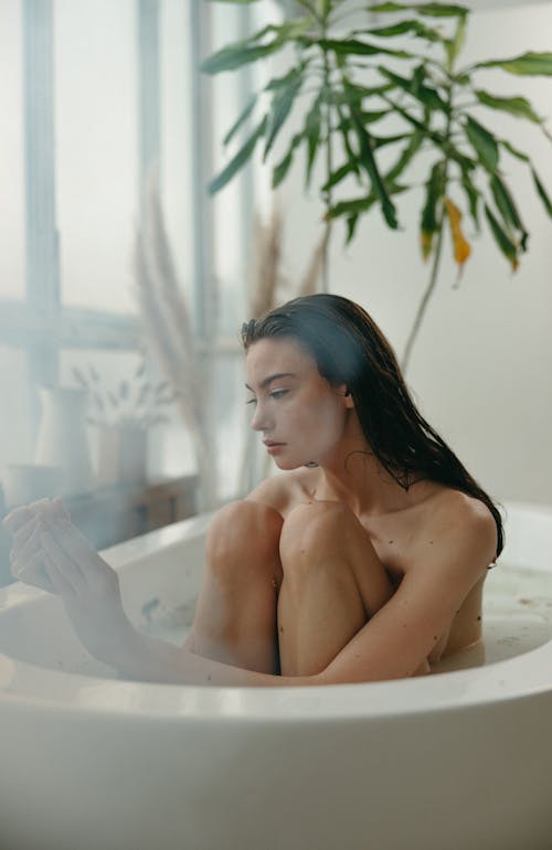 Woman Sitting on a Bathtub with Water