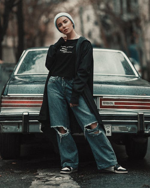 Stylish Woman Standing Beside a Vintage Car