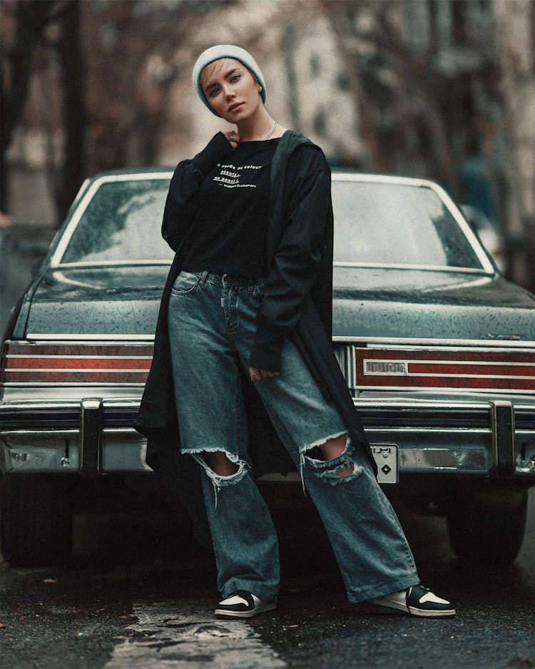 Stylish Woman Standing Beside A Vintage Car