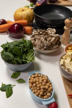 A variety of fresh ingredients including spinach, chickpeas, and mushrooms for vegan cooking.