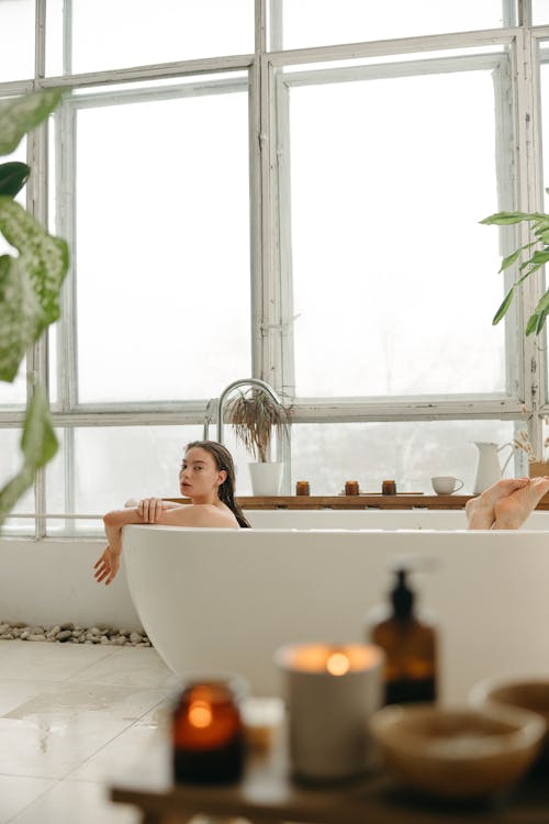 Woman taking bath, man sitting on side of bathtub, looking down at woman -  Stock Photo - Masterfile - Premium Royalty-Free, Code: 695-03381854