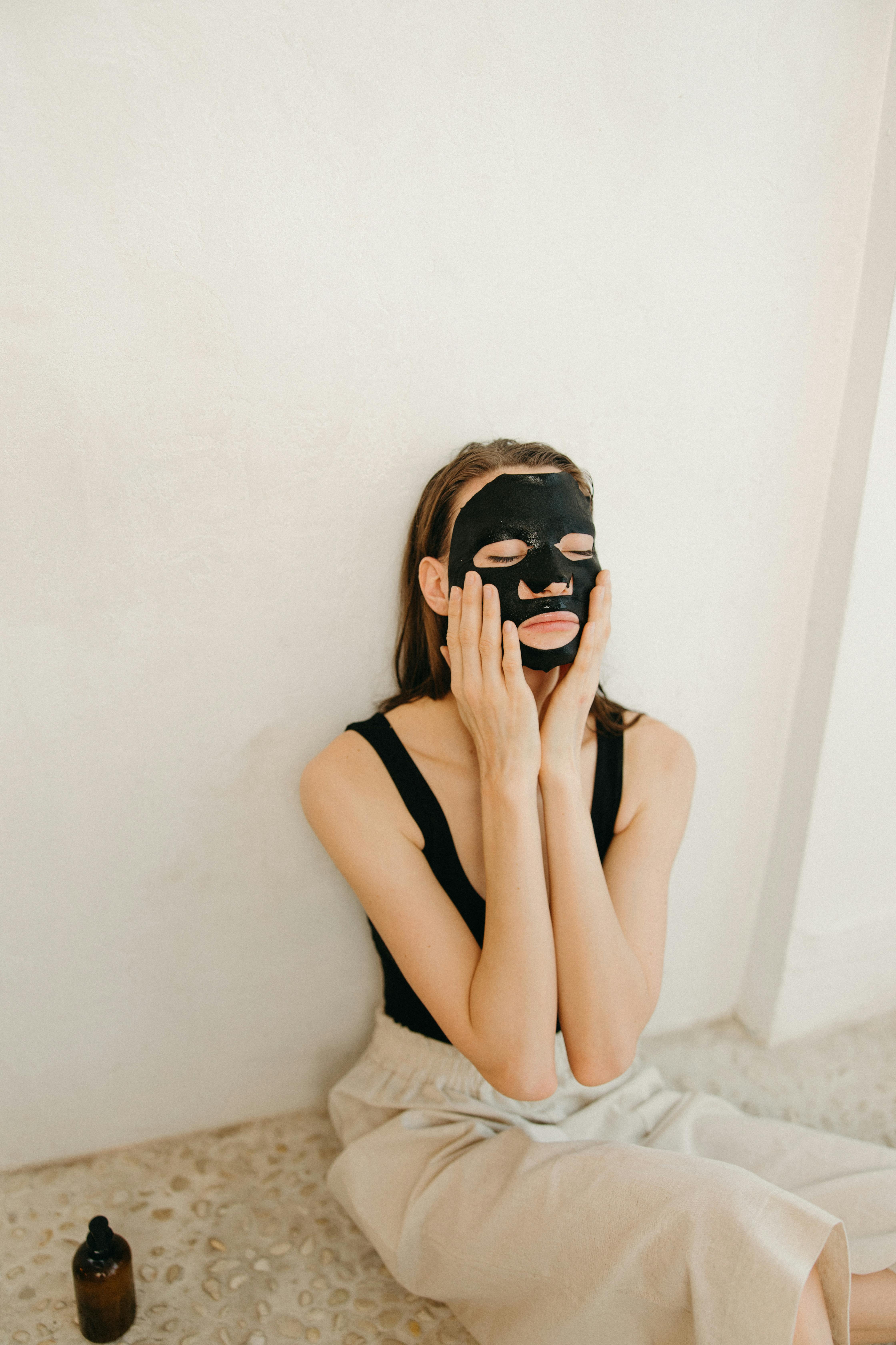 Woman applying a cosmetic mask to her face — the quiet beauty ritual