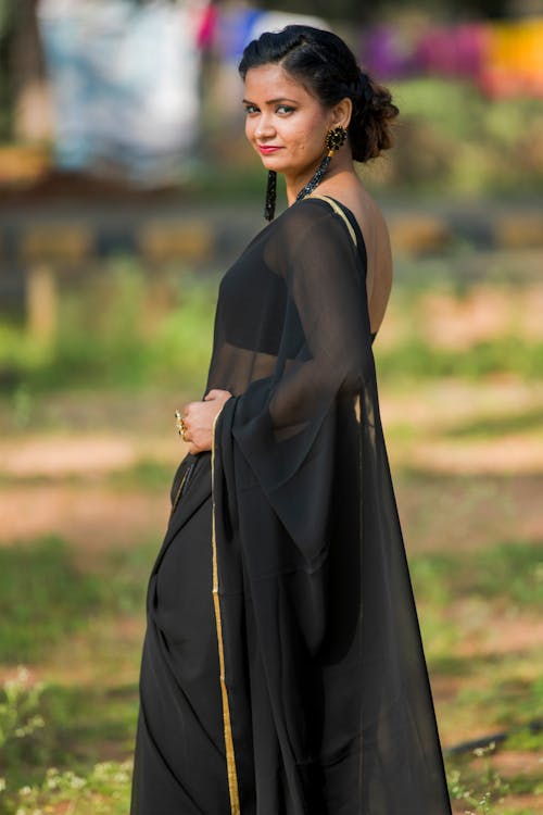 Woman in Black Long Dress and Large Dangling Earrings