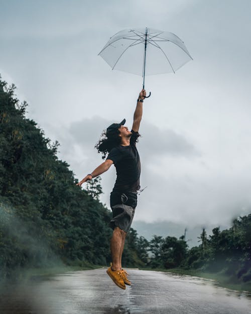 Free Man in Black Shirt Holding an Umbrella Stock Photo