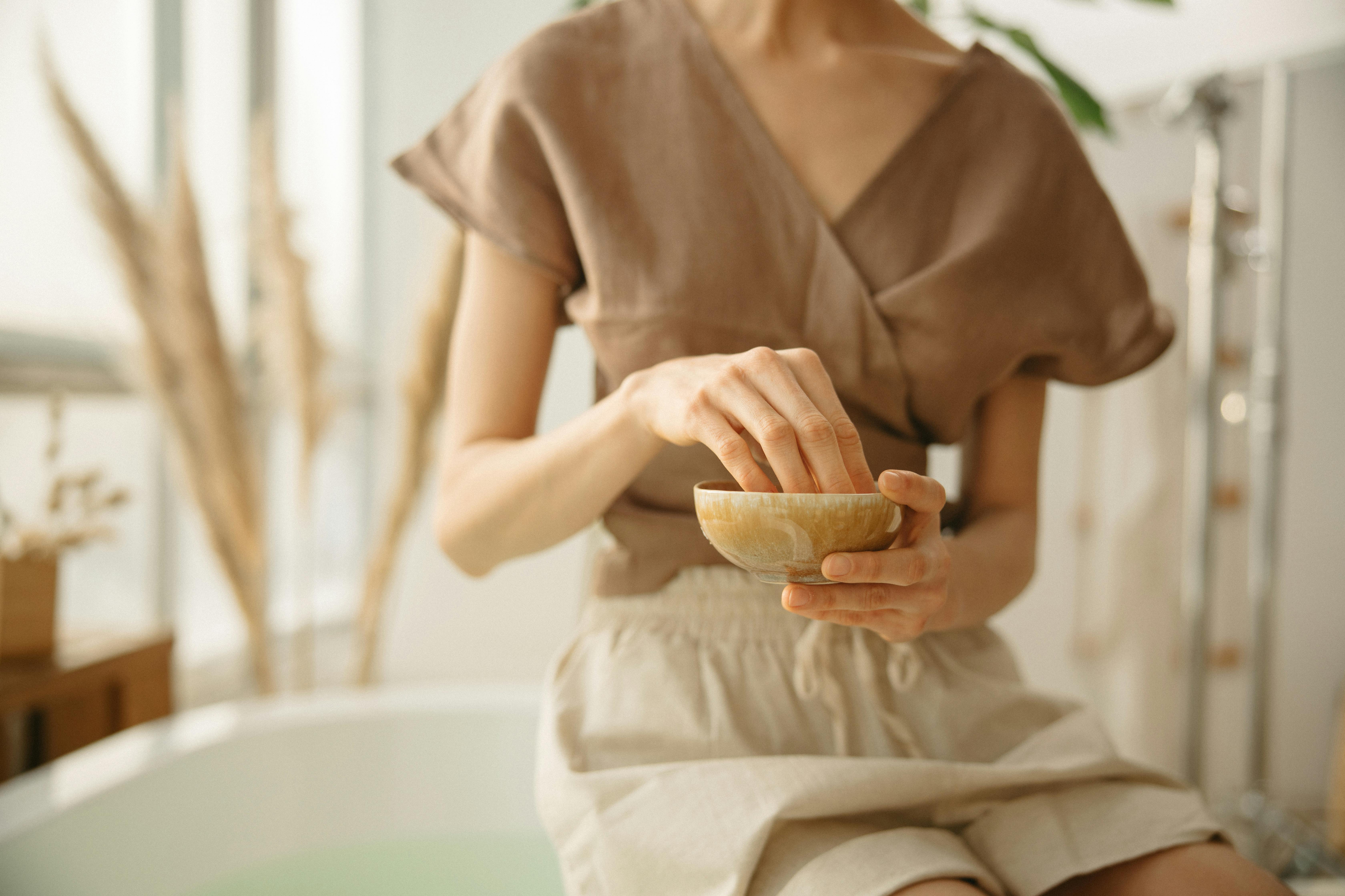 woman in brown button up shirt sitting on white bathtub