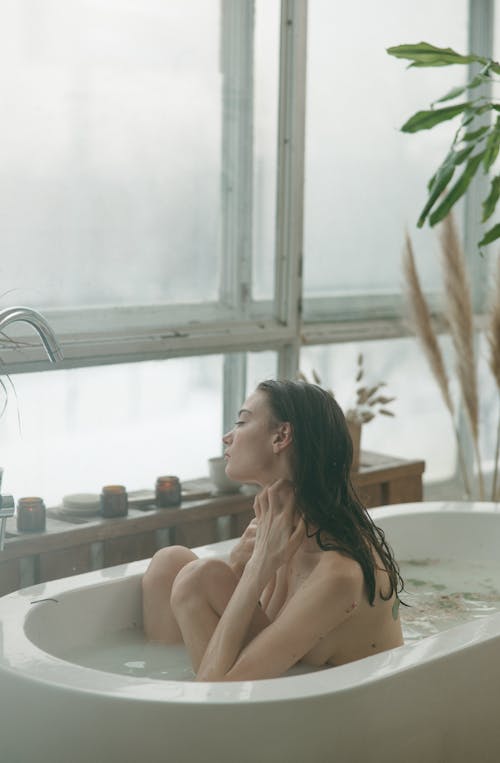 Photo of a Woman Bathing in Bathtub