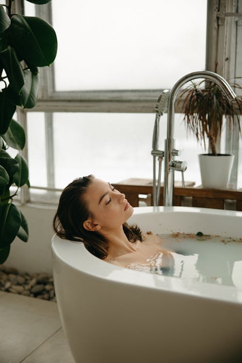 Free Woman Relaxing in a Bathtub Stock Photo