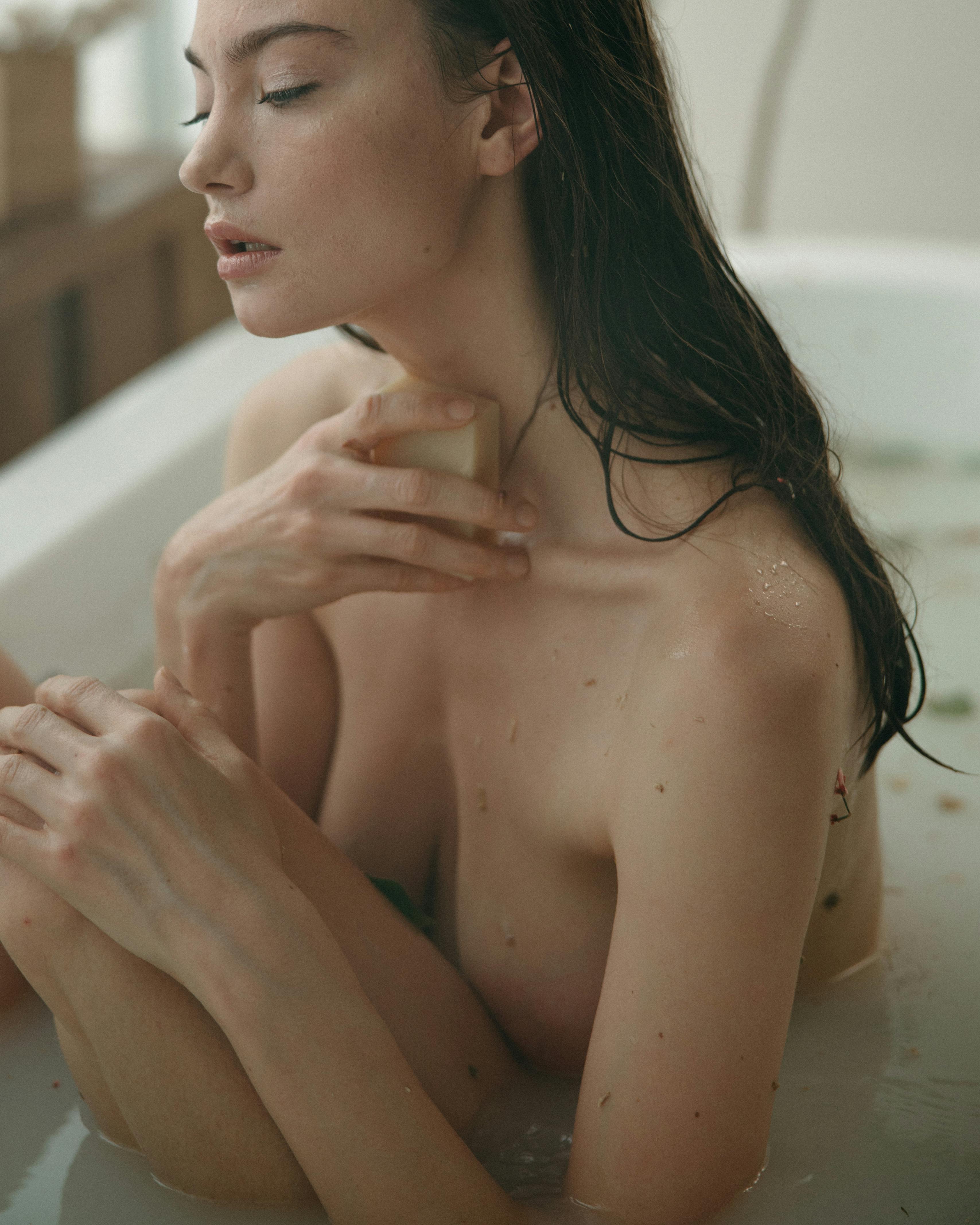 woman holding a soap in the bathtub