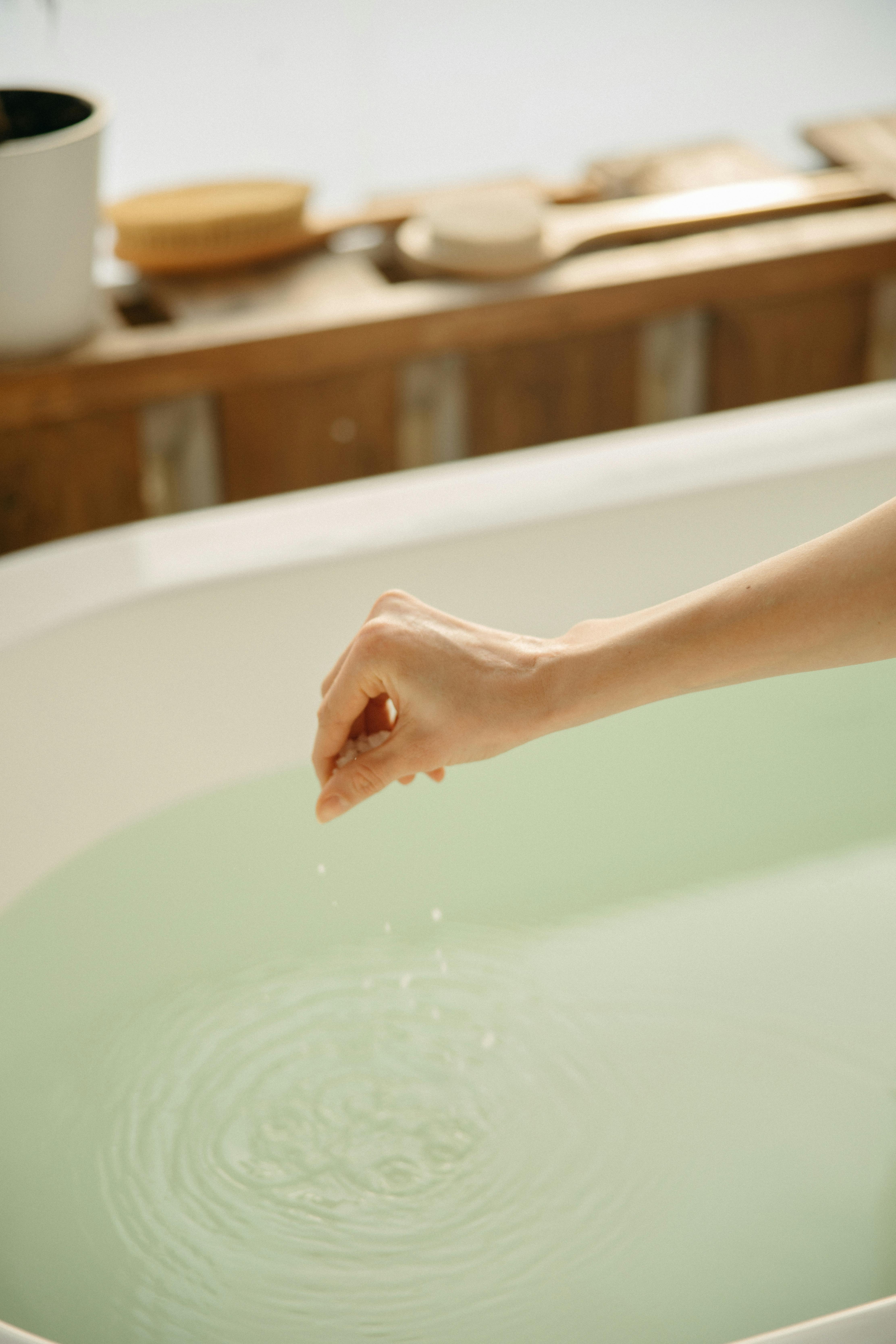 persons foot on white ceramic bathtub