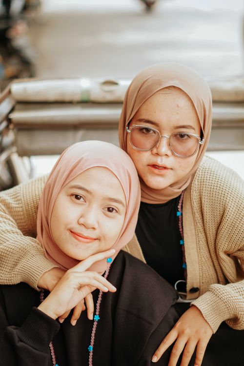 Free Close-up portrait of two women in hijabs smiling warmly outdoors in Cirebon, Indonesia. Stock Photo