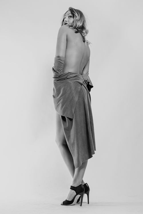 Free Graceful black and white image of a woman posing in stylish fashion attire. Stock Photo