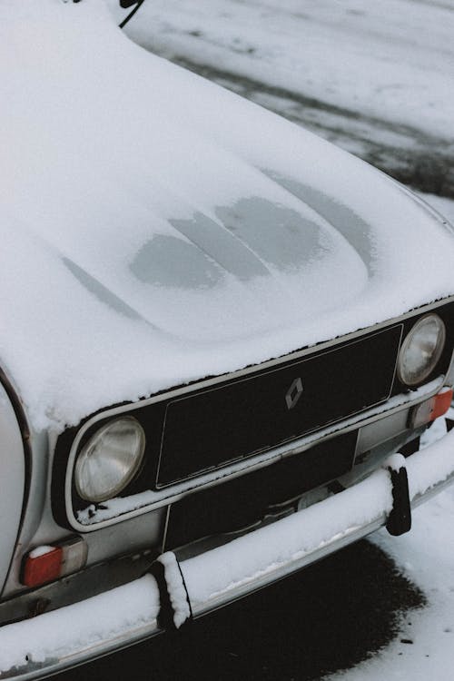 Retro car hood covered with snow