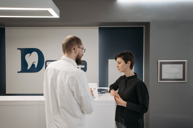 Man Talking With Woman At Dental Clinic