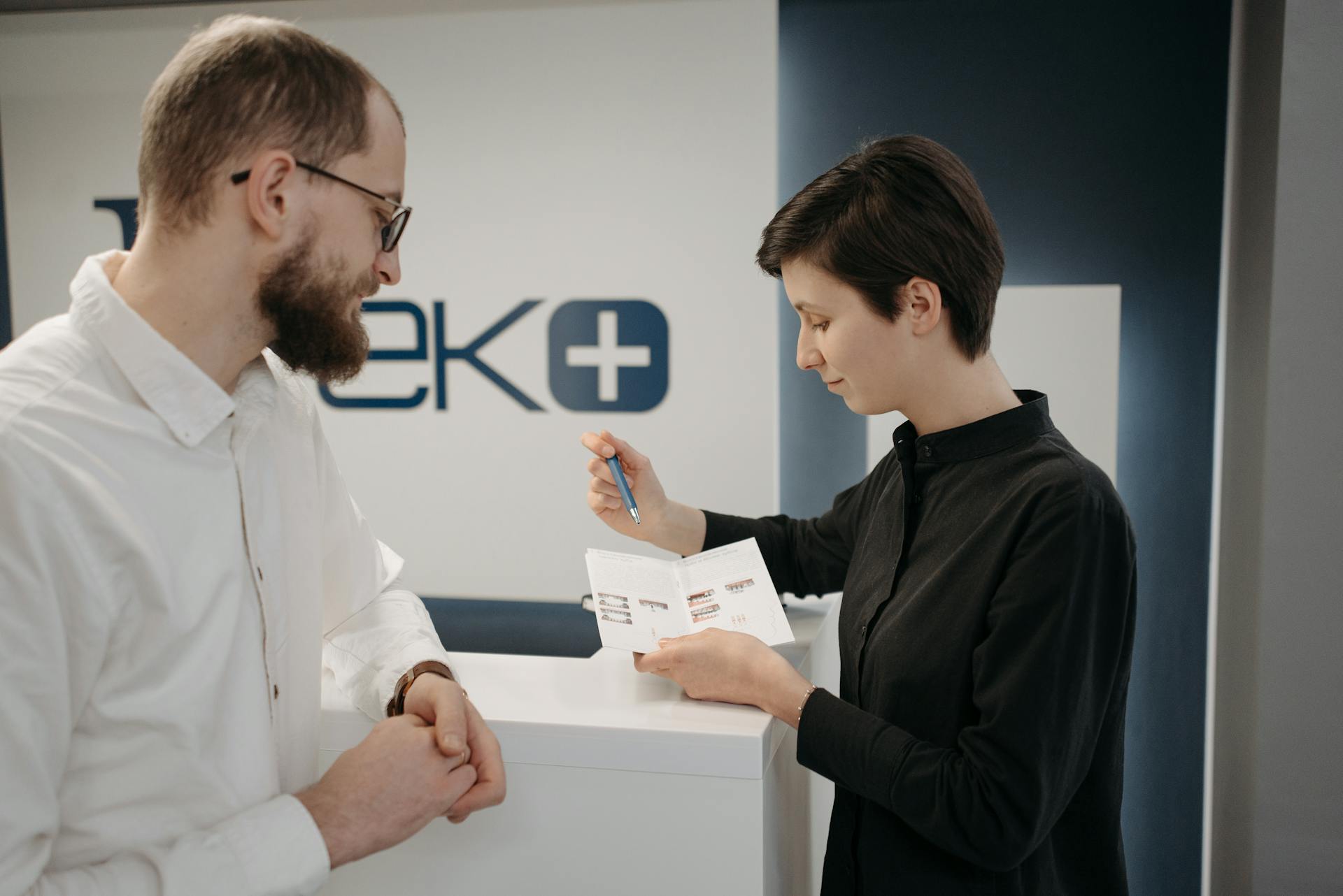 Woman in Black Long Sleeves Explaining the Services on a Customer