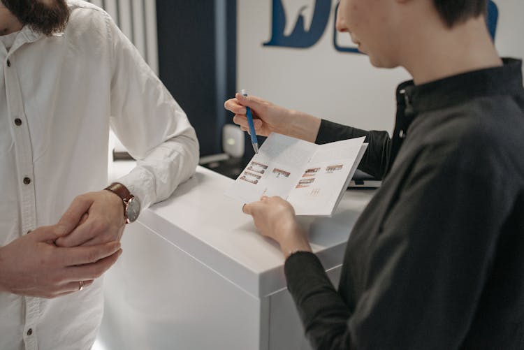 A Woman Explaining The Contents Of The Brochure