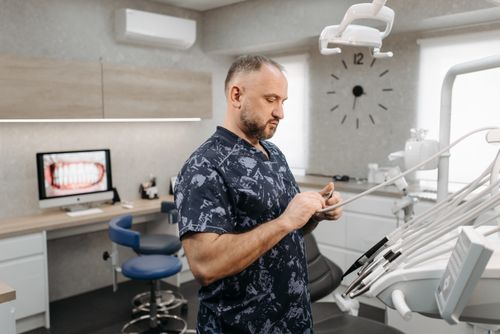 Free Dentist preparing dental tools in a modern dental office with equipment and patient images. Stock Photo