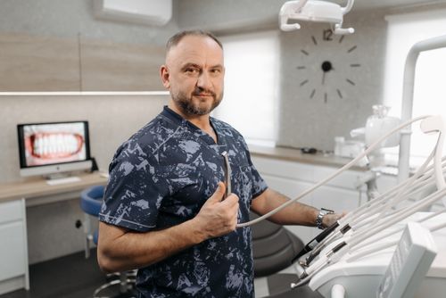 Free A portrait of a dentist in a modern clinic, showcasing dental equipment. Stock Photo