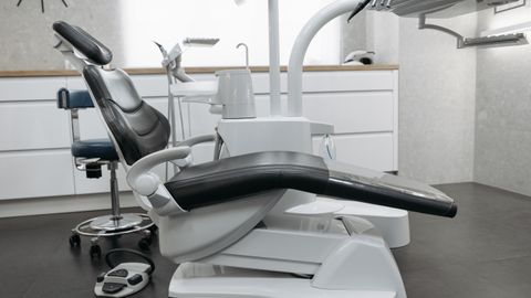 A contemporary dental office with a sleek dental chair and equipment, perfect for healthcare themed needs.
