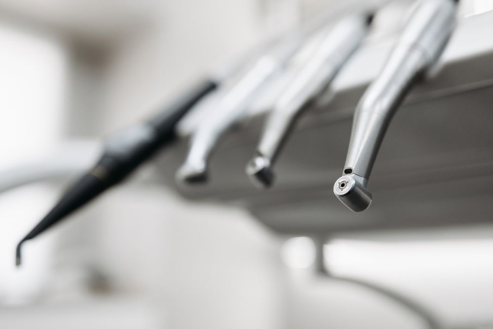 Close-up of stainless steel dental handpieces in a holder