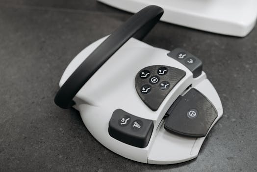 Close-up photo of a modern white gadget with black control buttons on a textured surface.