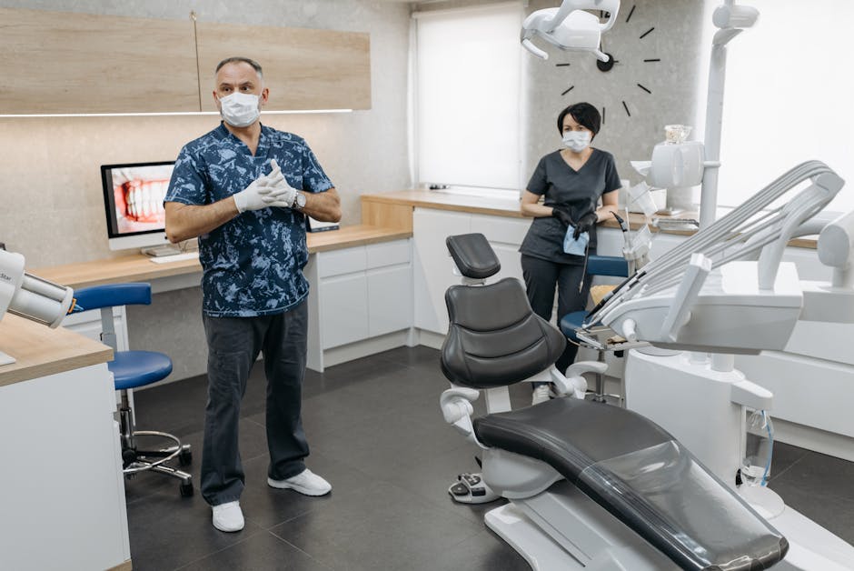 How Dental Insurance Covers Costs After Annual Maximums A dentist and assistant in a well-equipped modern dental clinic wearing masks and gloves.