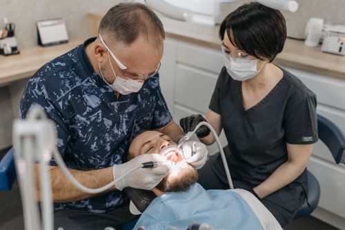 Free Dentist and assistant conducting a dental exam with protective gear. Stock Photo
