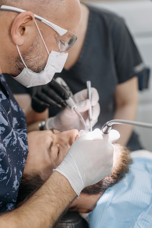 Free Man Checking a Patient's Teeth Stock Photo