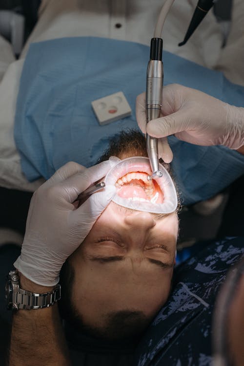 A Man Getting Treated by a Dentist