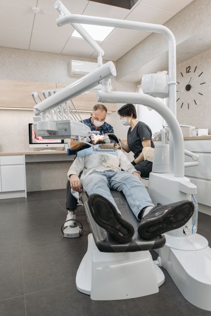 Dentista y asistente atendiendo a un paciente