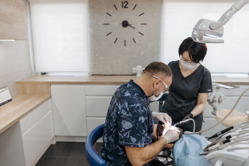 Free Dentist and assistant perform dental checkup in a modern clinic with medical equipment. Stock Photo