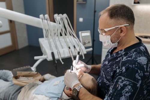 Free Dentist examining patient's teeth in a clinical setting with modern equipment. Stock Photo