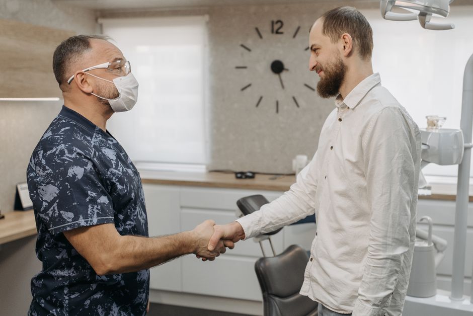online eye care products Canada - Dentist and patient handshake in a modern clinic setting. Professional healthcare interaction.
