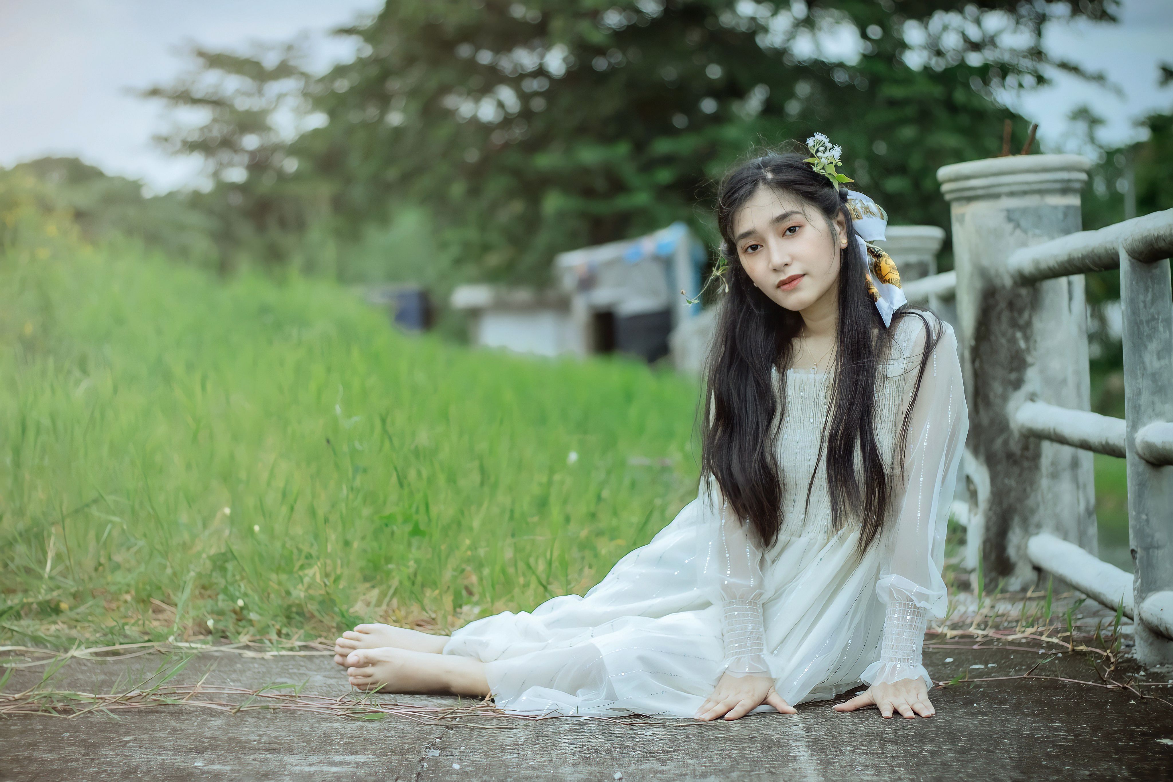 A Woman in Black Dress Sitting on Green Grass Field · Free Stock Photo